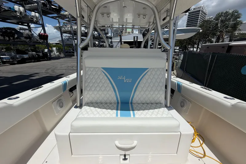 Slide: The Image of 2009 SeaVee 340B Cuddy boat interior with cushioned seating and storage, docked outdoors. - 31