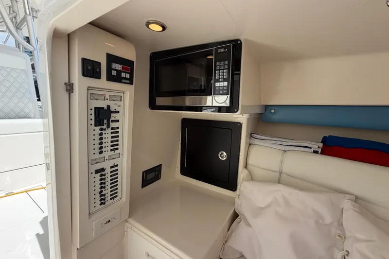 Slide: The Image of 2009 SeaVee 340B Cuddy interior with microwave, control panel, and storage. - 36