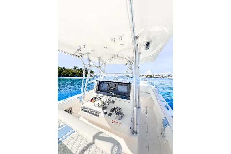 Slide: The Image of 2009 SeaVee 340B Cuddy boat helm with navigation equipment on calm blue water. - 45