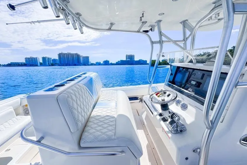 Slide: The Image of 2009 SeaVee 340B Cuddy boat interior with helm, overlooking city skyline and blue water. - 46