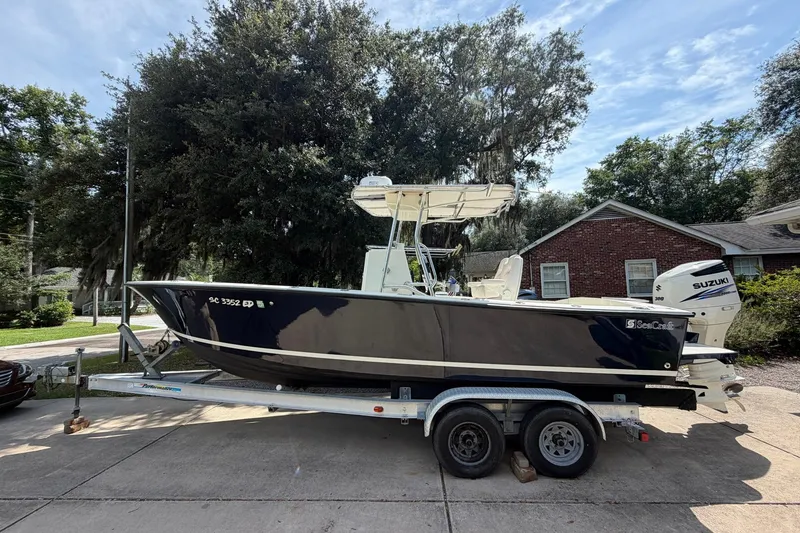 The Image of 1976 SeaCraft SC 23 Classic boat on trailer, parked in residential driveway. - 1