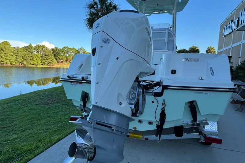 Slide: The Image of 2026 Mako 226 Center Console boat with powerful outboard motor by a serene lake. - 3
