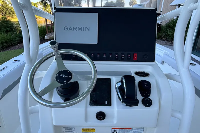 Slide: The Image of 2026 Mako 226 Center Console boat dashboard with Garmin display and steering wheel. - 13
