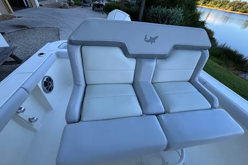 Slide: The Image of 2026 Mako 226 Center Console boat with cushioned seating near a serene lake. - 4