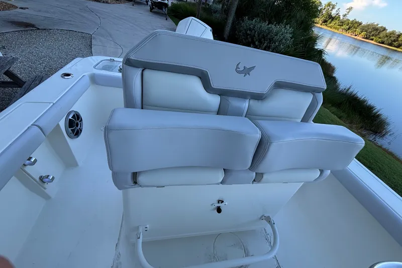 Slide: The Image of 2026 Mako 226 Center Console boat interior with cushioned seating by a serene lake. - 6