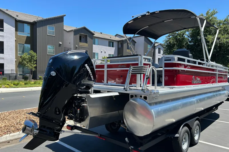 Slide: The Image of 2026 Sun Tracker Sportfish 24 XP3 pontoon boat with Mercury outboard motor in a parking lot. - 4