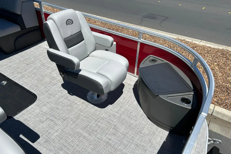 Slide: The Image of 2026 Sun Tracker Sportfish 24 XP3 boat interior with gray captain's chair and storage console. - 11