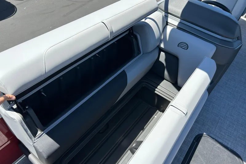 Slide: The Image of 2026 Sun Tracker Sportfish 24 XP3 boat seat storage compartment open, showcasing spacious interior. - 13