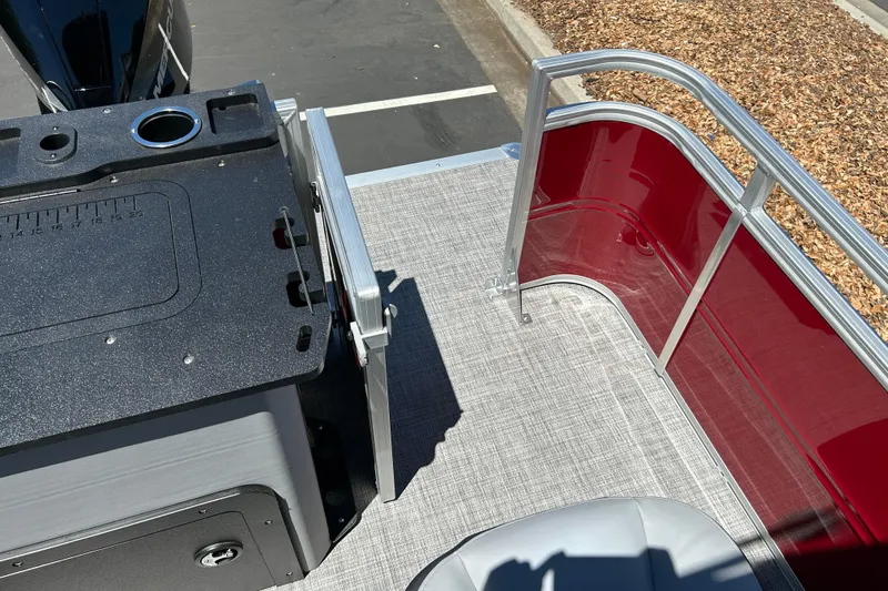 Slide: The Image of 2026 Sun Tracker Sportfish 24 XP3 boat deck with red railing and utility station. - 24