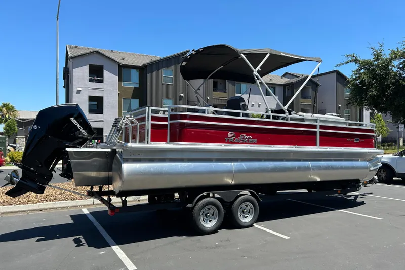Slide: The Image of 2026 Sun Tracker Sportfish 24 XP3 pontoon boat on trailer in parking lot. - 3
