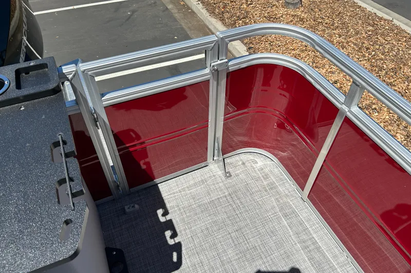 Slide: The Image of 2026 Sun Tracker Sportfish 24 XP3 boat with red paneling and aluminum railing. - 23
