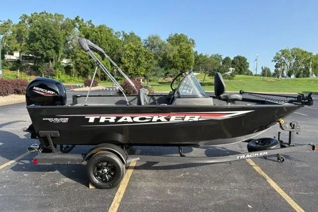 Slide: The Image of 2026 Tracker Pro Guide V-175 WT boat on trailer, parked outdoors with trees in background. - 3