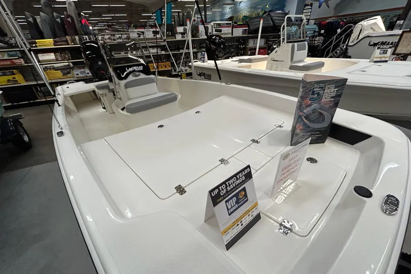 Slide: The Image of 2026 Mako Pro Skiff 17 CC boat displayed in a showroom with promotional materials. - 2
