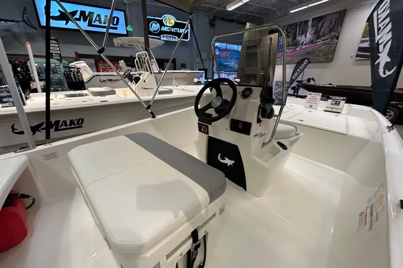 Slide: The Image of 2026 Mako Pro Skiff 17 CC boat interior with steering console and seating in showroom. - 4