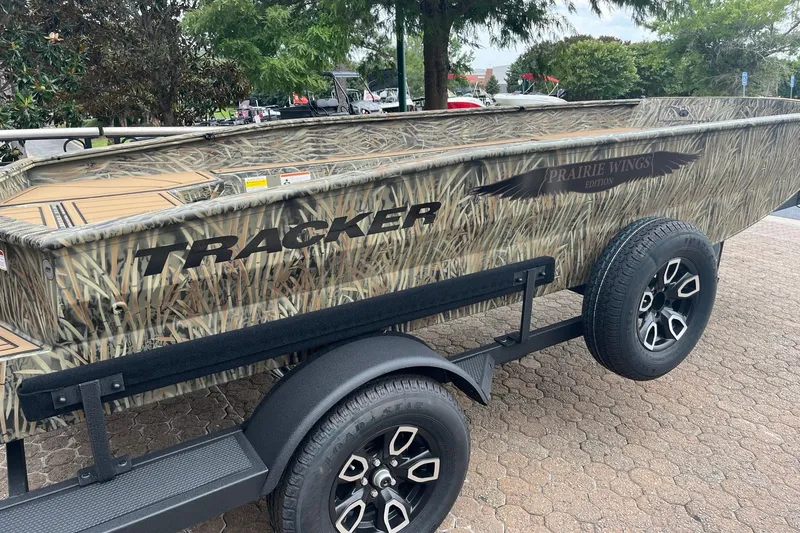 Slide: The Image of 2026 Tracker Grizzly 1650 T Prairie Wings Edition boat with camouflage design on a trailer. - 4
