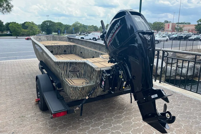 Slide: The Image of 2026 Tracker Grizzly 1650 T Prairie Wings Edition boat with Mercury engine, parked outdoors. - 3