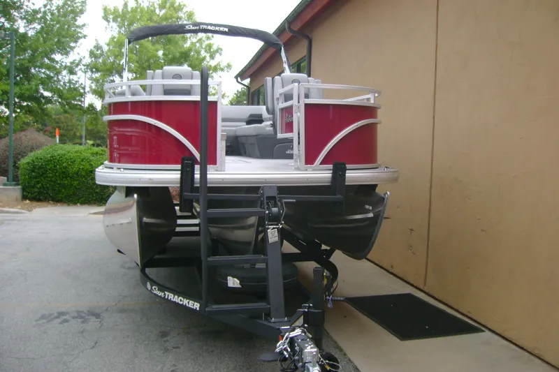 Slide: The Image of 2026 Sun Tracker Sportfish 24 XP3 pontoon boat on trailer, parked outdoors. - 7