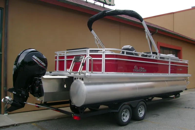 Slide: The Image of 2026 Sun Tracker Sportfish 24 XP3 pontoon boat with Mercury outboard motor on trailer. - 4