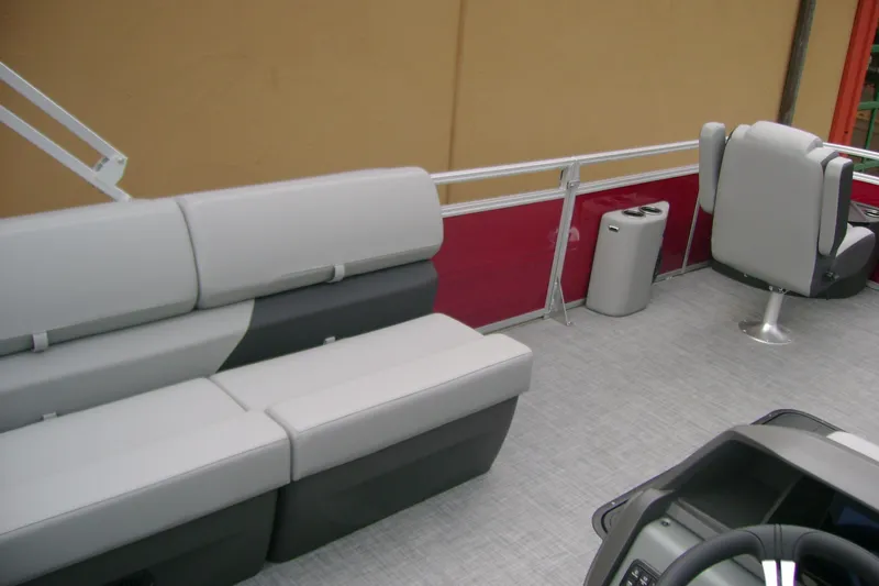 Slide: The Image of 2026 Sun Tracker Sportfish 24 XP3 pontoon boat interior with gray seating and red paneling. - 13