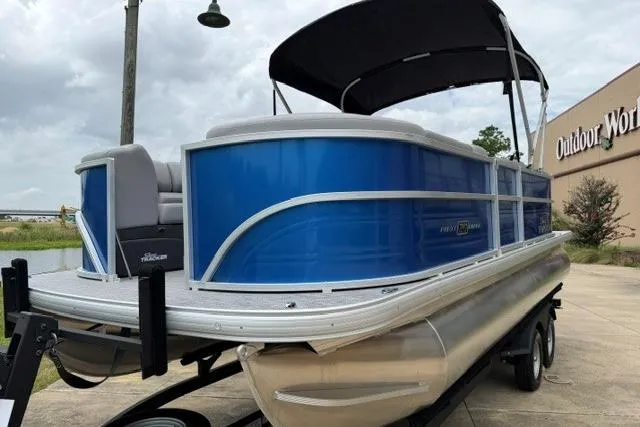Slide: The Image of 2026 Sun Tracker Party Barge 20 DLX pontoon boat with blue exterior, parked outdoors. - 7