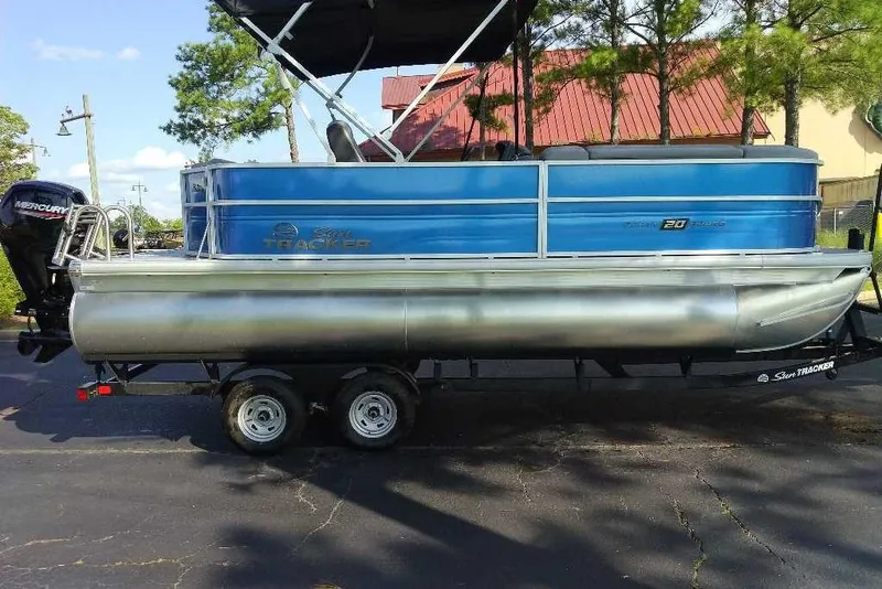 Slide: The Image of 2026 Sun Tracker Party Barge 20 DLX pontoon boat on trailer, parked outdoors. - 3