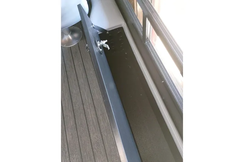 Slide: The Image of Open storage compartment on 2026 Ranger 223FC boat, featuring sleek design and secure lock. - 13