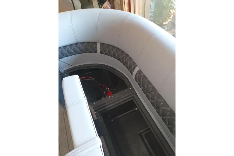 Slide: The Image of 2026 Ranger 223FC boat interior with cushioned seating and storage compartment. - 11