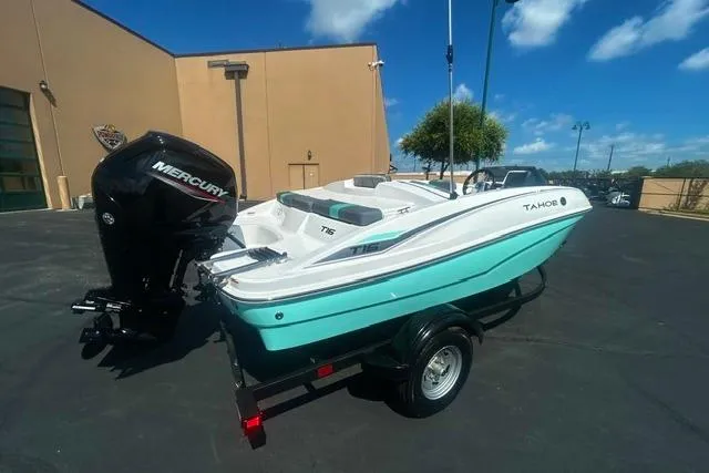 Slide: The Image of 2026 Tahoe T16 boat with Mercury engine on trailer, parked outdoors. - 1