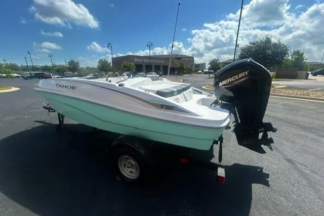 Slide: The Image of 2026 Tahoe T16 boat with Mercury engine on trailer, parked outdoors under blue sky. - 3