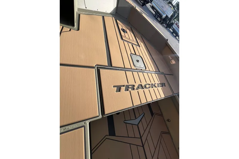 Slide: The Image of 2026 Tracker Grizzly 1756 T Marsh boat interior with tan flooring and logo. - 5