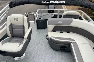 Slide: The Image of 2026 Sun Tracker Bass Buggy 18 DLX pontoon boat interior with cushioned seating and helm. - 4