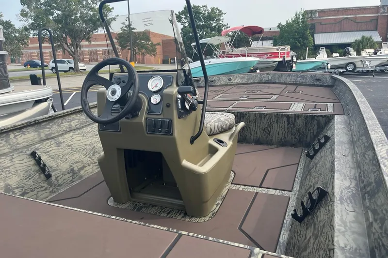 Slide: The Image of 2026 Tracker Grizzly 2072 CC boat interior with steering console and camouflage design. - 6
