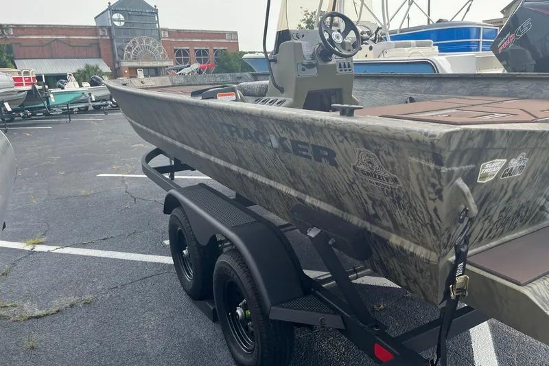 Slide: The Image of 2026 Tracker Grizzly 2072 CC boat on trailer in parking lot, camo design. - 2