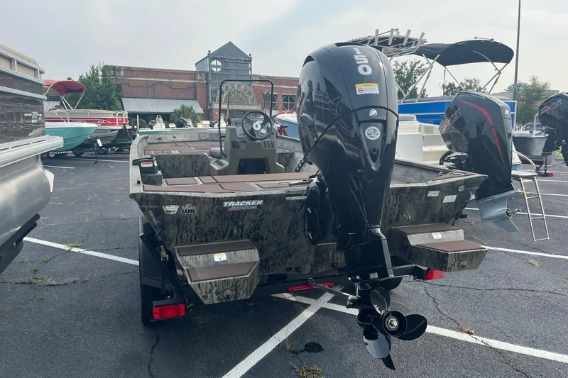 Slide: The Image of 2026 Tracker Grizzly 2072 CC boat with powerful outboard motor in a parking lot. - 3