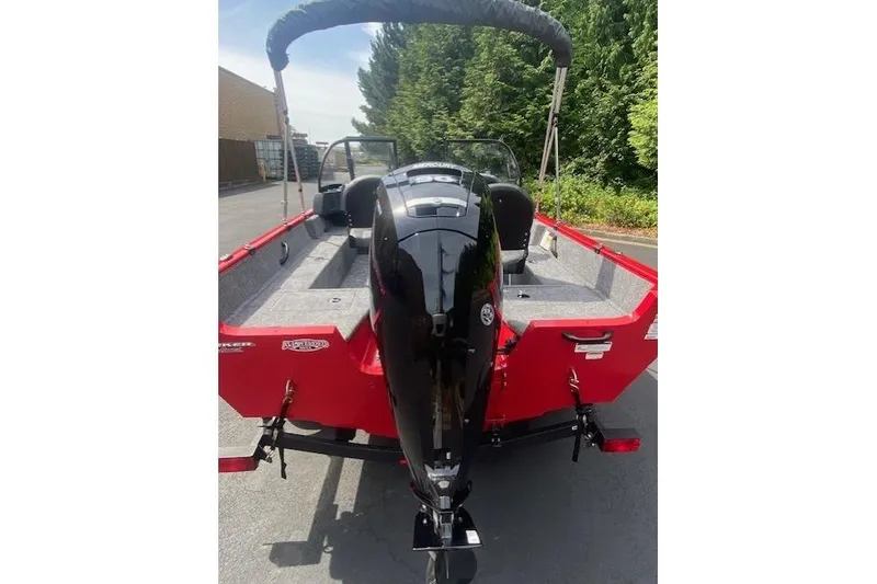 Slide: The Image of 2026 Tracker Pro Guide V-16 WT boat, red exterior, parked outdoors with motor visible. - 2