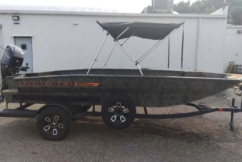 The Image of 2026 Tracker Grizzly 1756 T Marsh boat with canopy on trailer, parked outdoors. - 0