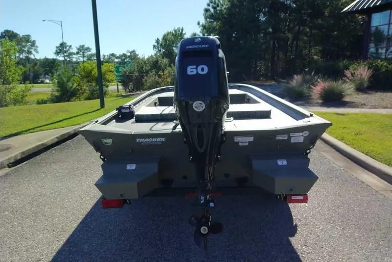 Slide: The Image of 2026 Tracker Grizzly 1860 CC boat with Mercury 60 engine, parked outdoors. - 3