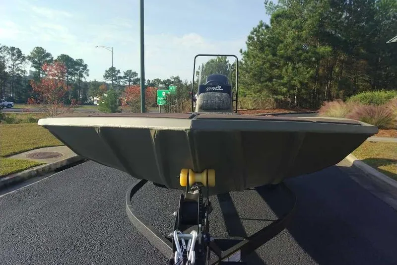 Slide: The Image of 2026 Tracker Grizzly 1860 CC boat on trailer, parked outdoors with trees in background. - 6