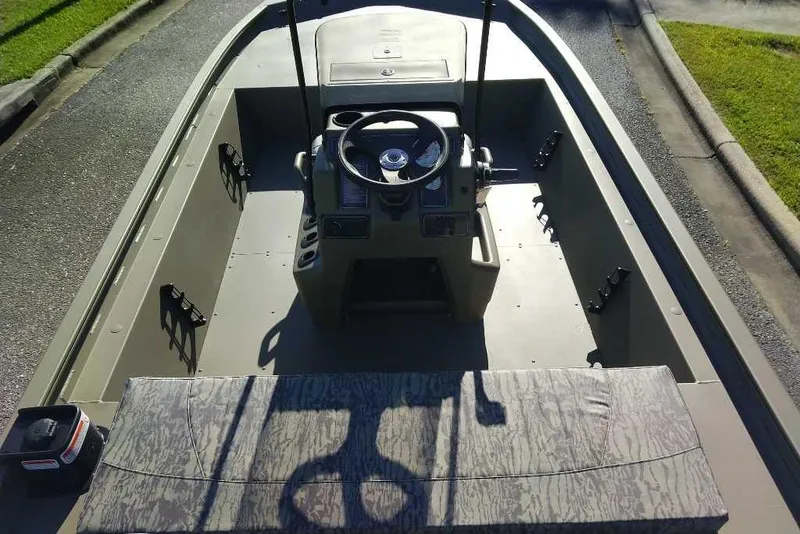 Slide: The Image of 2026 Tracker Grizzly 1860 CC boat interior with steering console and seating. - 2