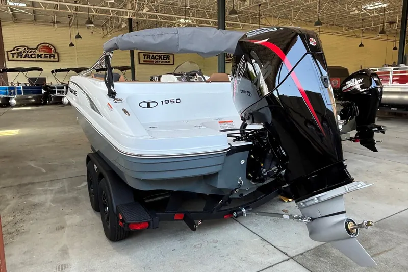 Slide: The Image of 2026 Tahoe 1950 boat with powerful outboard motor in showroom setting. - 2