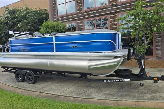 Slide: The Image of 2026 Sun Tracker Party Barge 22 XP3 pontoon boat on trailer, parked outdoors. - 6