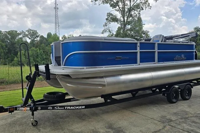 Slide: The Image of 2026 Sun Tracker Party Barge 22 XP3 pontoon boat on trailer, parked outdoors. - 4