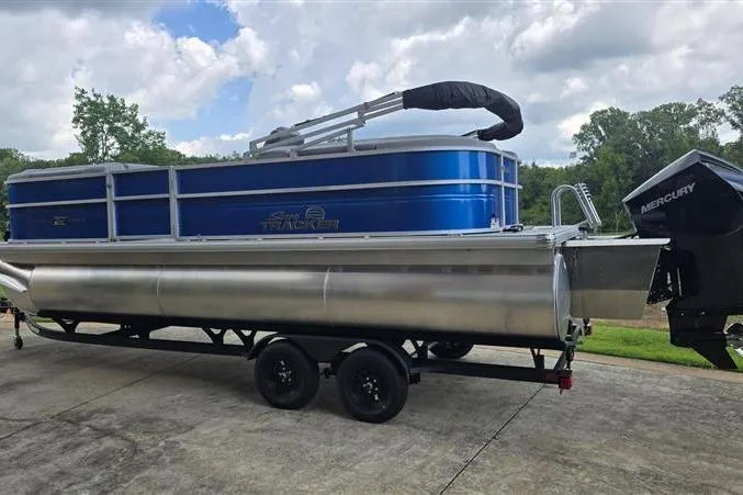 Slide: The Image of 2026 Sun Tracker Party Barge 22 XP3 pontoon boat on trailer, featuring a Mercury outboard motor. - 3