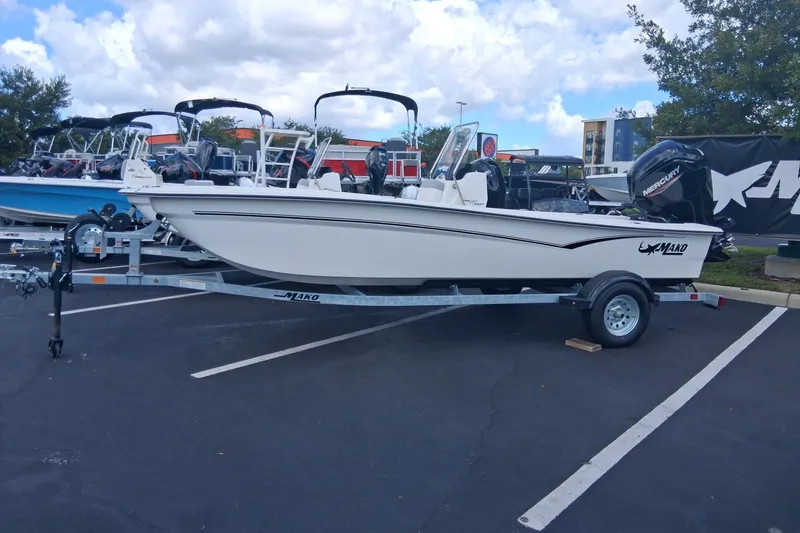 The Image of 2026 Mako Pro Skiff 17 CC boat on trailer in parking lot under cloudy sky. - 0