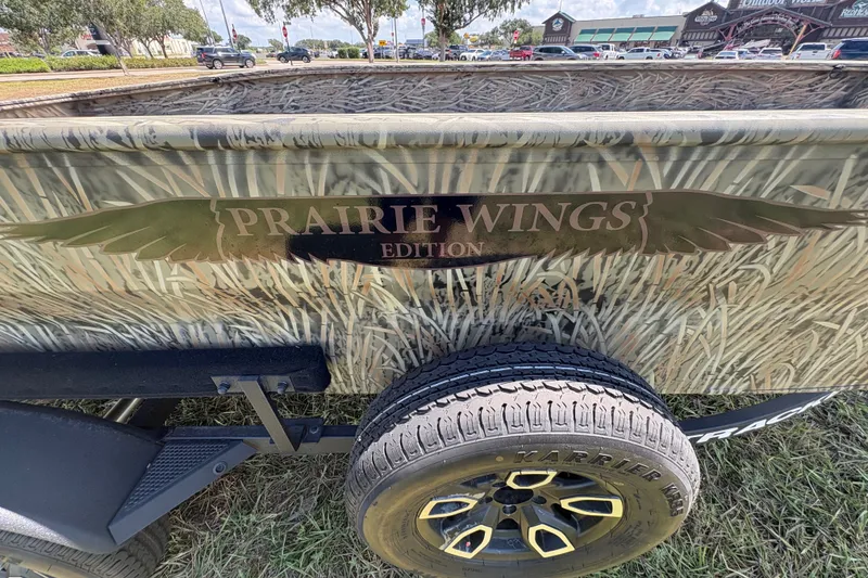 Slide: The Image of 2026 Tracker Grizzly 1650 T Prairie Wings Edition boat with camouflage design and branded tire. - 39