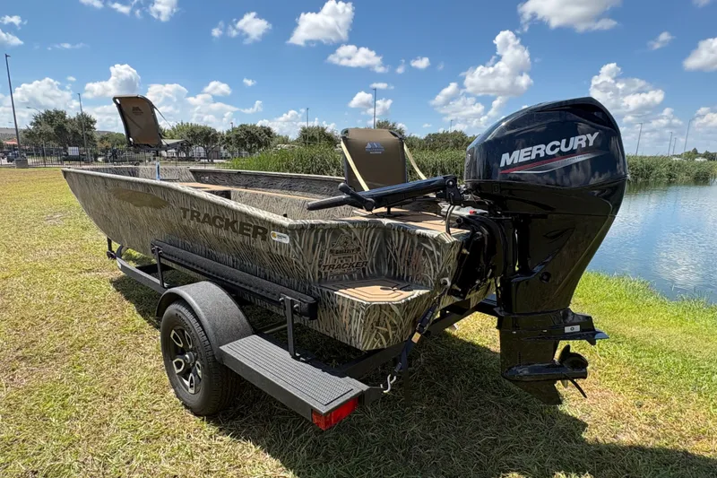 Slide: The Image of 2026 Tracker Grizzly 1650 T Prairie Wings Edition boat with Mercury engine by a lake. - 34
