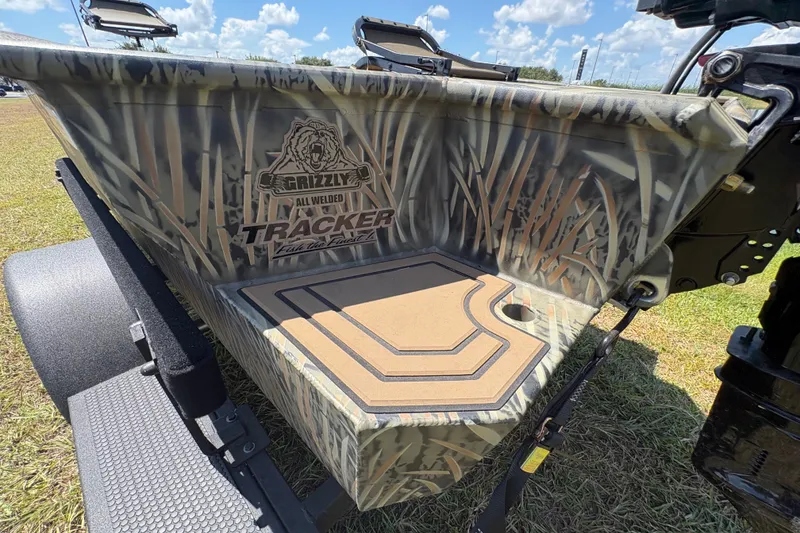 Slide: The Image of 2026 Tracker Grizzly 1650 T Prairie Wings Edition boat with camouflage design on grass. - 44
