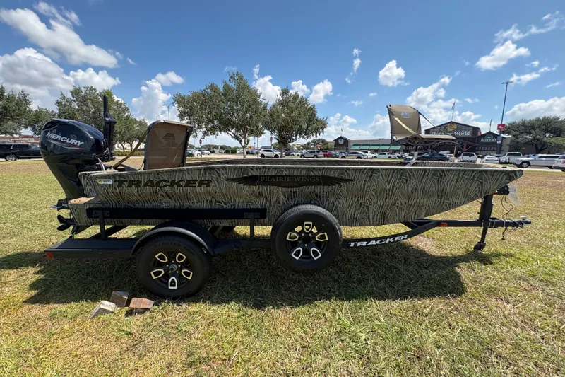 Slide: The Image of 2026 Tracker Grizzly 1650 T Prairie Wings Edition boat on trailer, parked outdoors. - 37