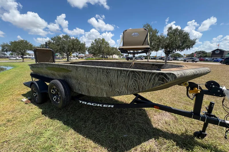 Slide: The Image of 2026 Tracker Grizzly 1650 T Prairie Wings Edition boat on trailer, grassy area, clear sky. - 38