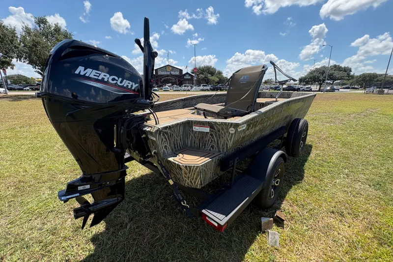 Slide: The Image of 2026 Tracker Grizzly 1650 T Prairie Wings Edition boat with Mercury engine on grassy field. - 36